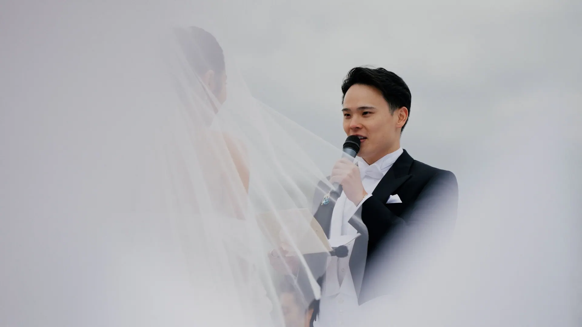 Groom speaking vows through the bride's veil