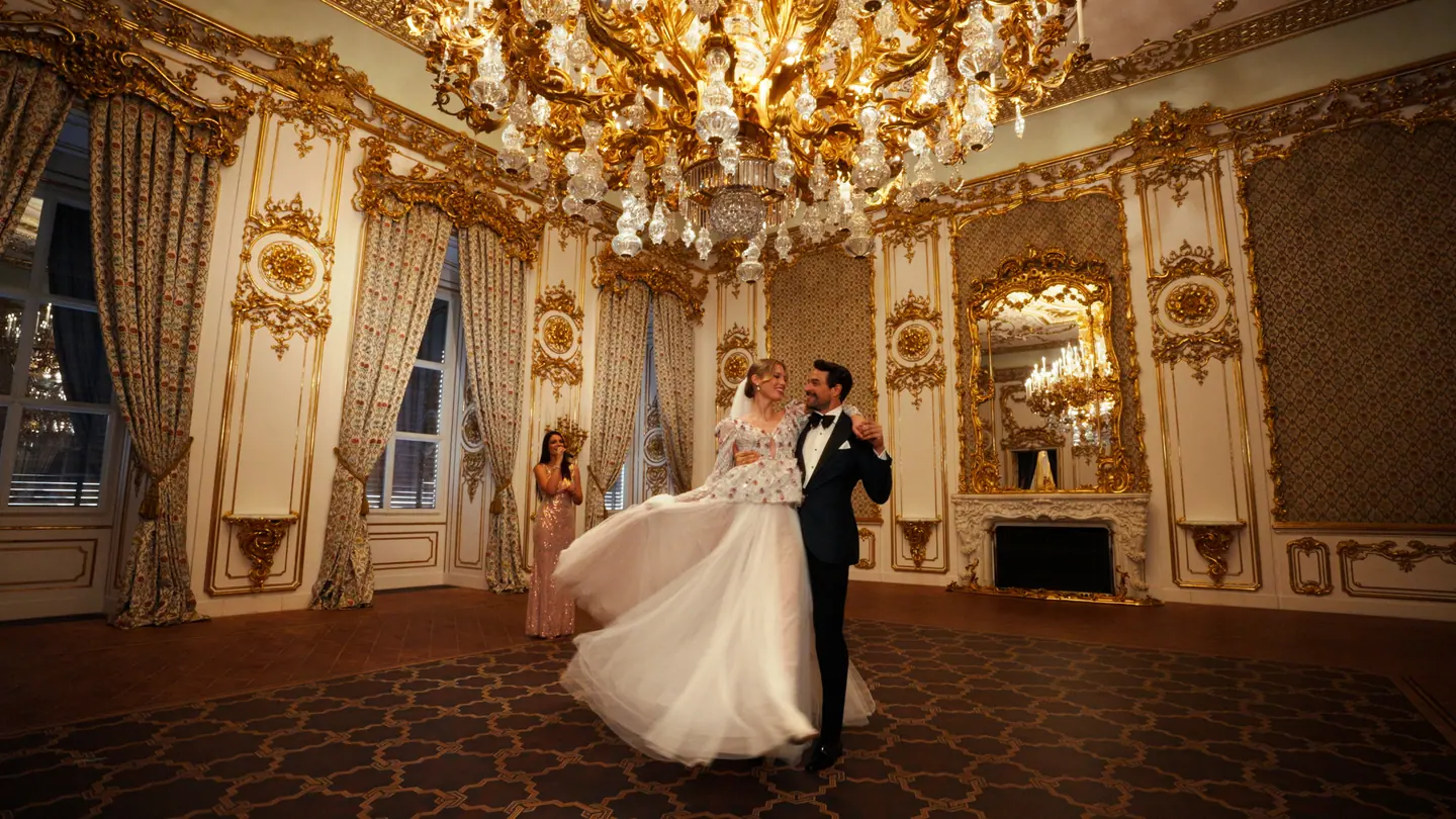 Bride and groom dancing beneath a chandelier