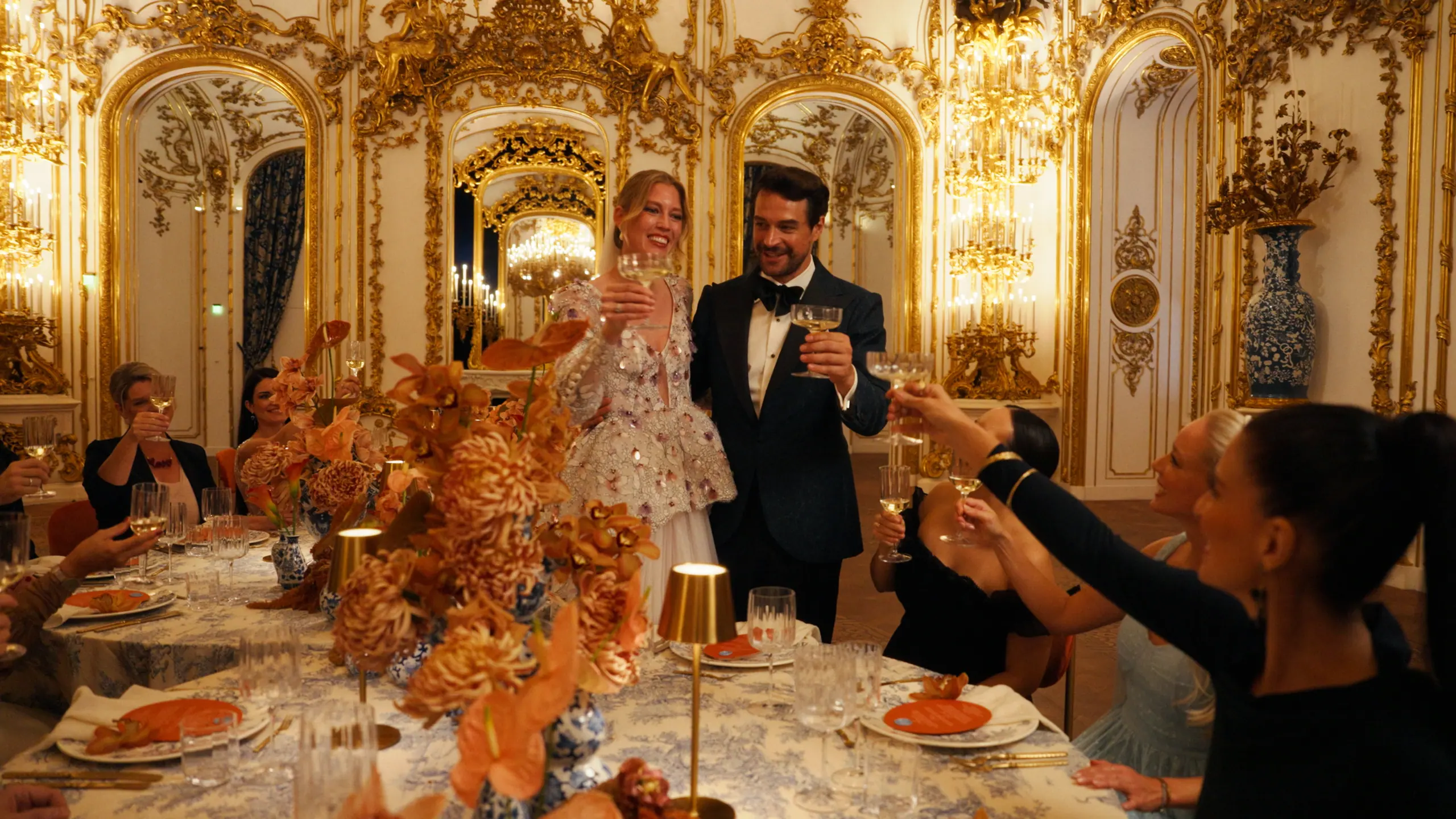 Bride and groom raising glasses inside the gilded Liechtenstein City Palace