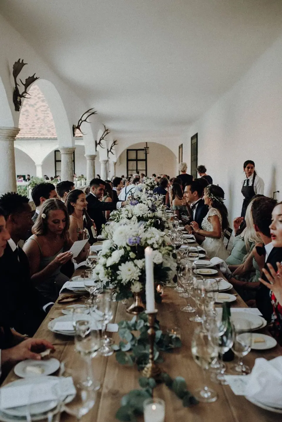 Long wedding dinner table beneath the Schloss Guntersdorf arcades